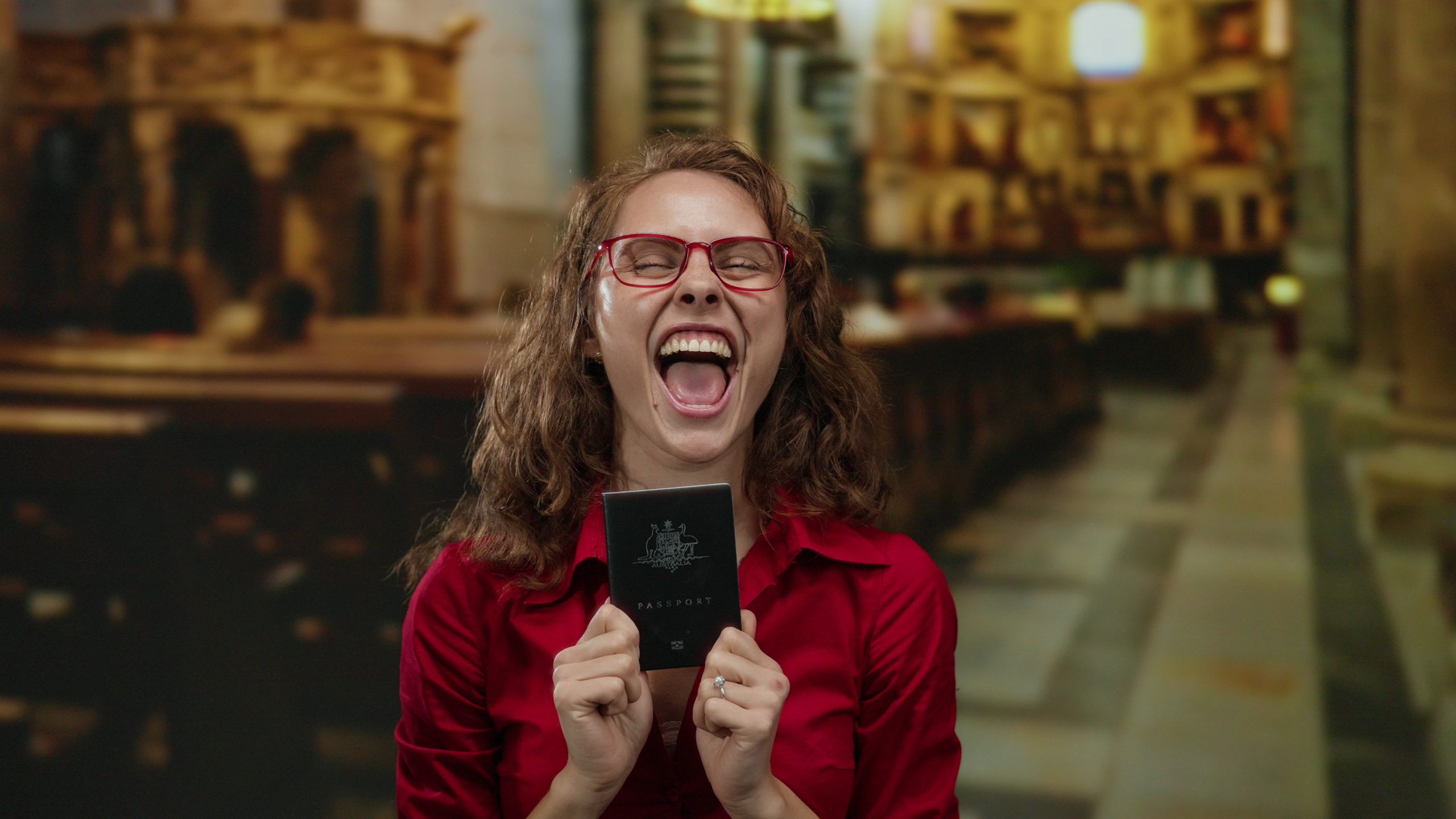 Australian Citizenship by Conferral or Descent | Beyond Horizons Migration Happy woman holding Australian passport symbolising citizenship assistance through our services.